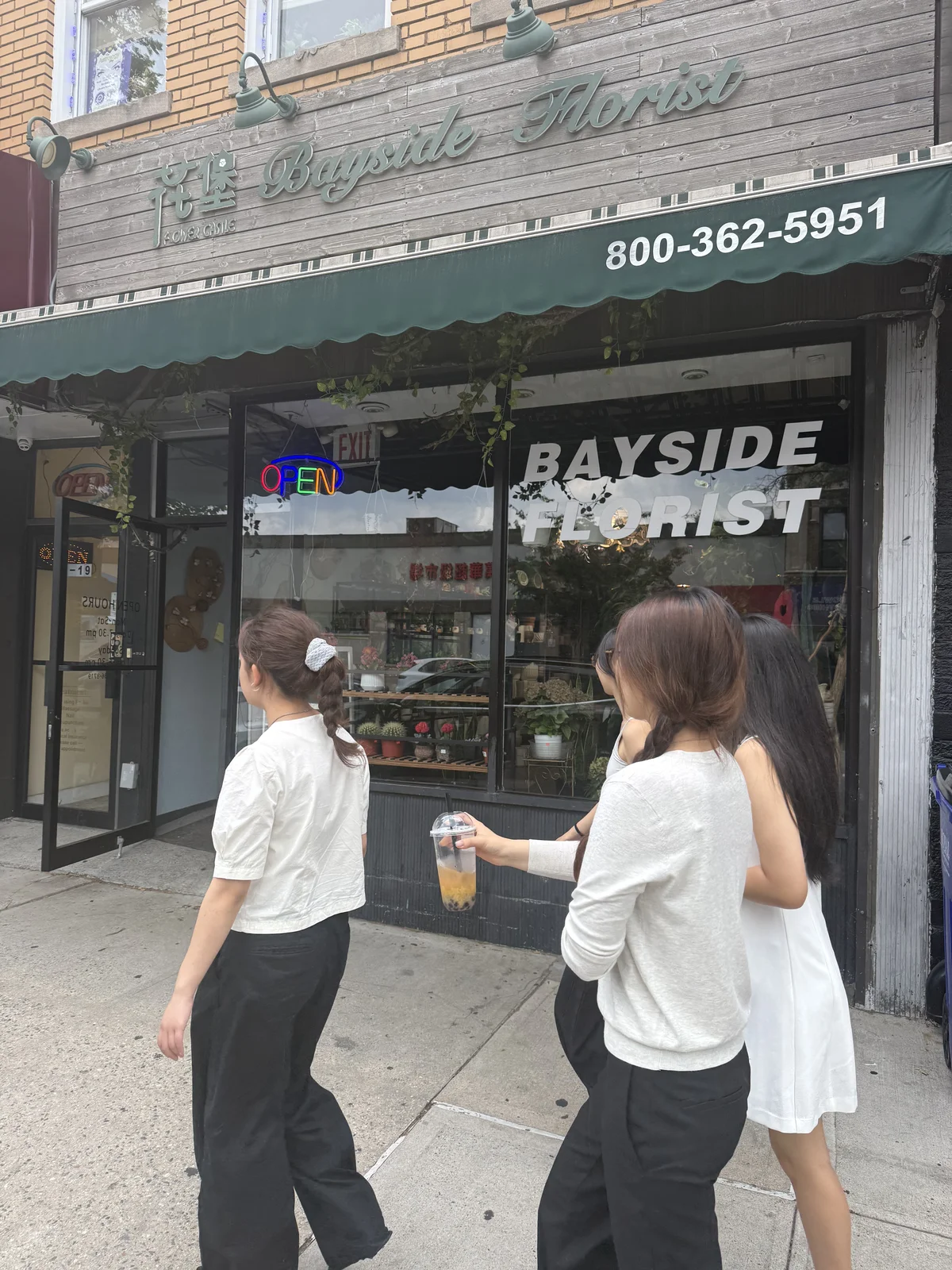 Bayside Florist storefront on Bell Boulevard in Bayside Queens with women walking past