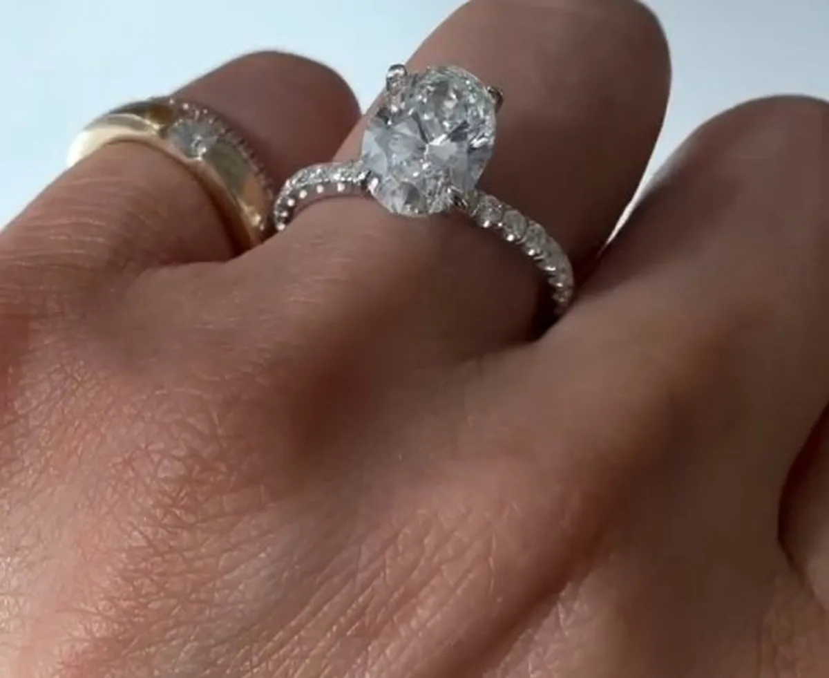Oval cut lab-grown diamond engagement ring with pave band in white gold on hand, Haejin Jewelry Brooklyn