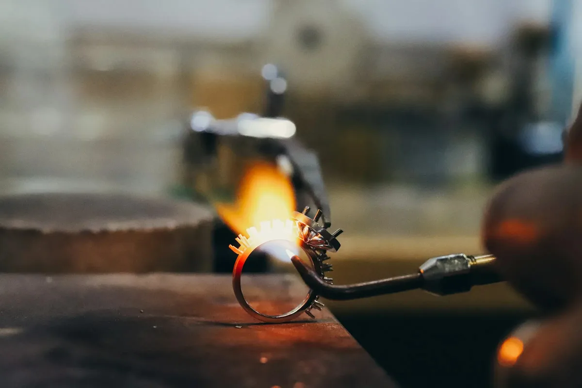 Gold ring being soldered with jeweler's torch at Haejin Jewelry Brooklyn studio