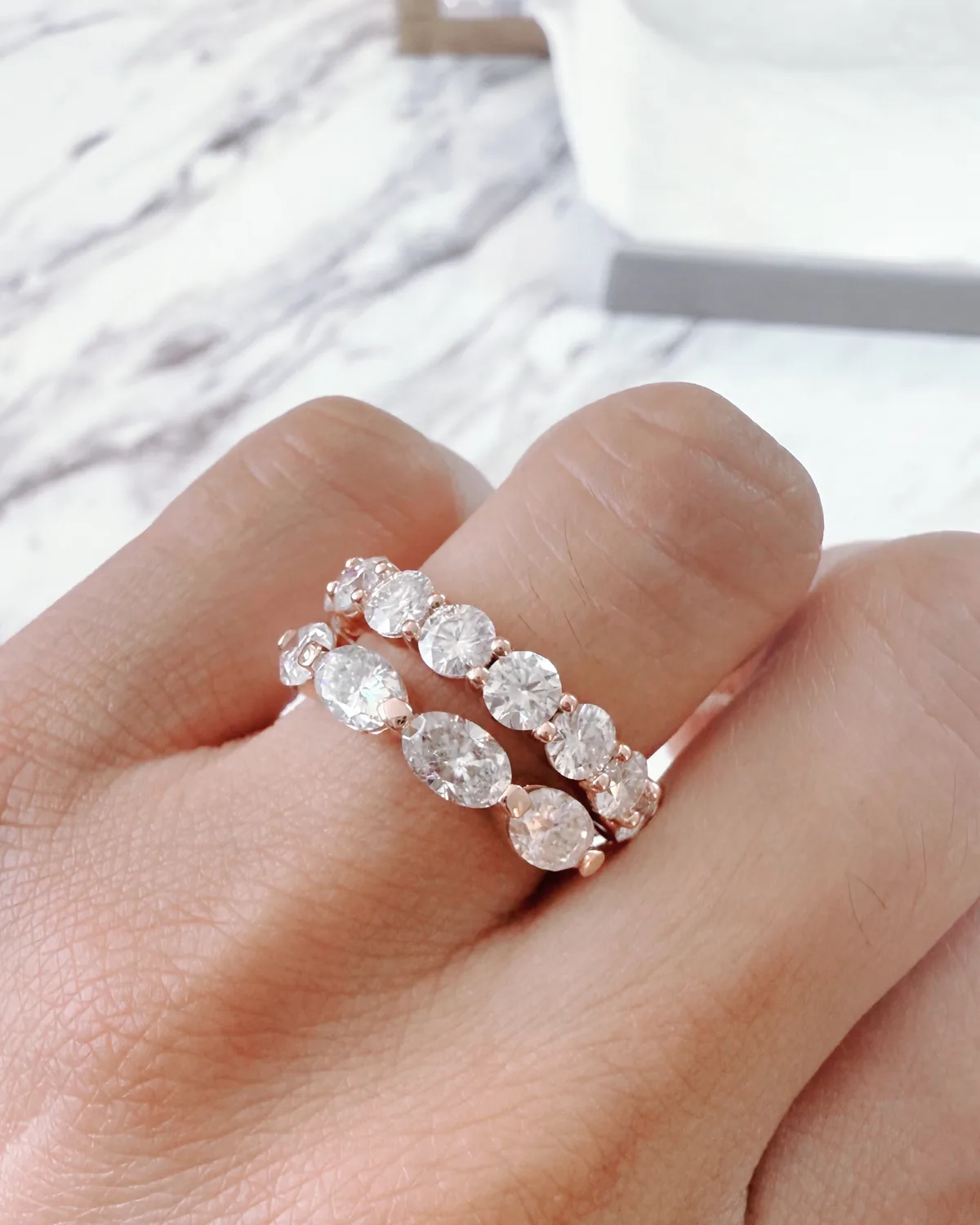 Two diamond eternity wedding bands in rose gold on hand, Haejin Jewelry Brooklyn
