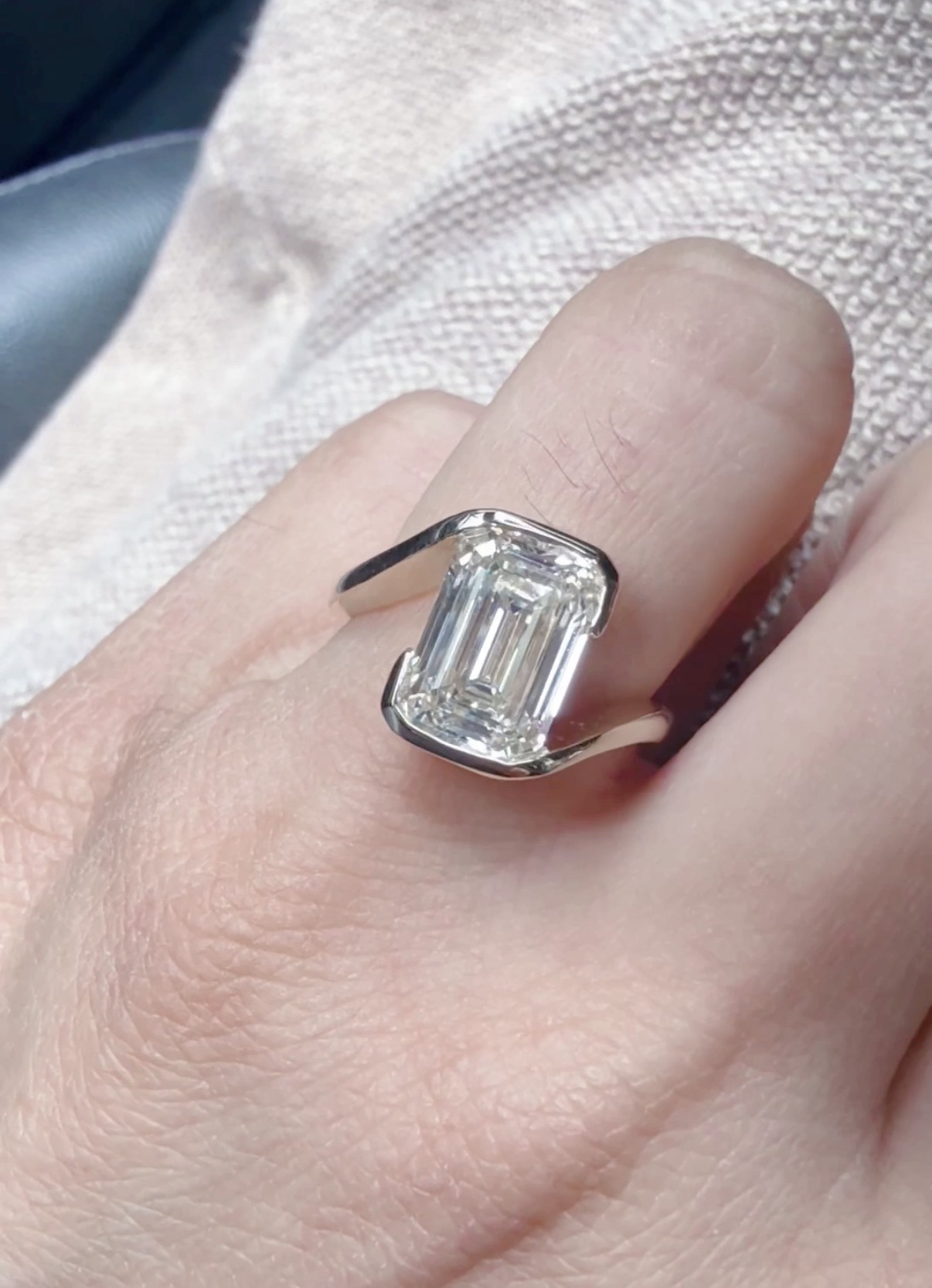 Emerald cut bezel set engagement ring on hand, designed at Haejin Jewelry Williamsburg Brooklyn