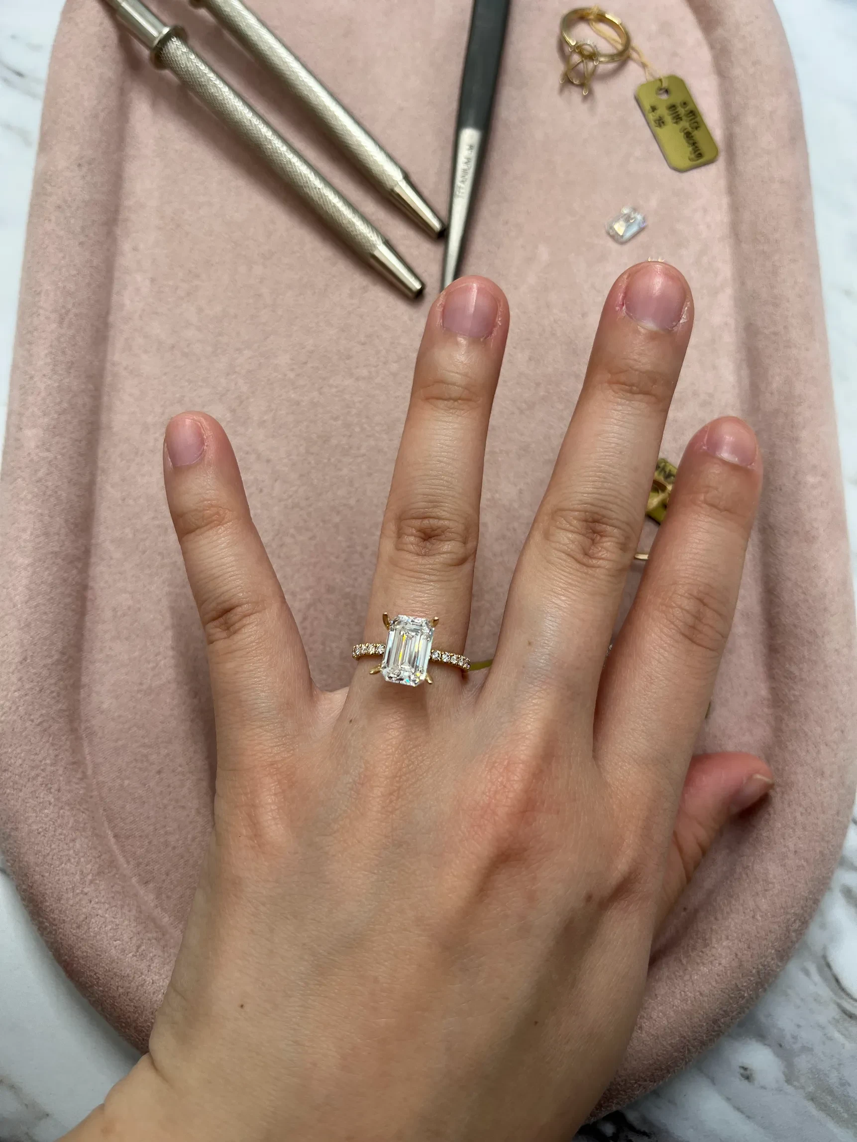 Emerald cut lab-grown diamond engagement ring with pave band tried on at Haejin Jewelry Williamsburg