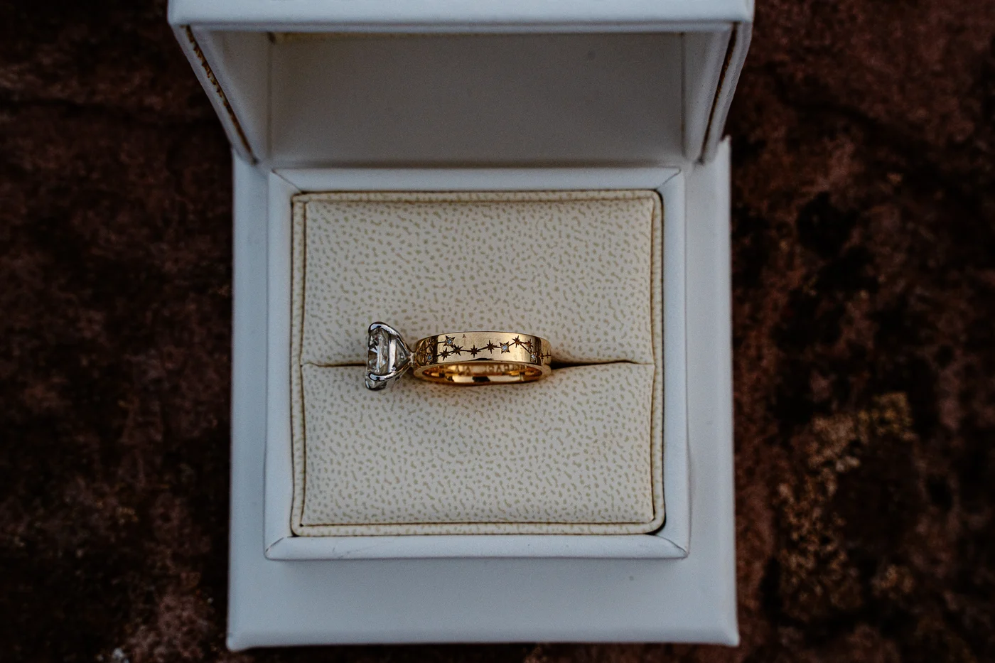 Profile of a cushion cut engagement ring showing the yellow gold band hand engraved with a star constellation, Haejin Jewelry Brooklyn